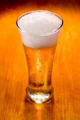 Beer glass over wooden background