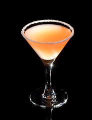 Martini glass with yellow cocktail isolated on black
