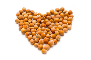 Hazelnuts as heart sign on white background