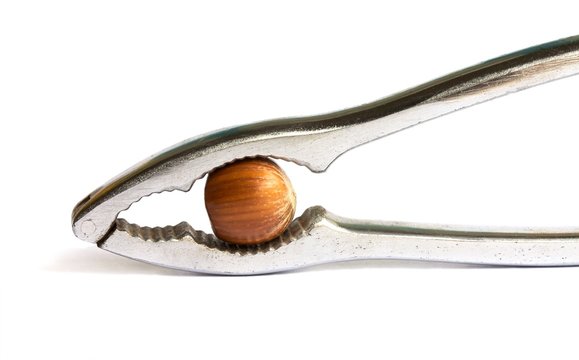 Metal nutcracker with a hazelnut isolated on a white background