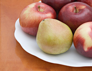Naklejka na ściany i meble Pear and apples on a white plate