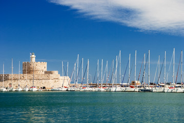 Yachts and old lighthouse in the harbor
