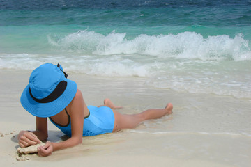 Fototapeta na wymiar Dziewczynka leży na plaży