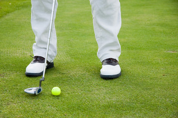 Golf player in special shoes on a putting green