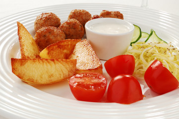 Fried meatballs with chips and vegetable salad