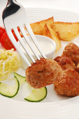 Fried meatballs with chips and vegetable salad