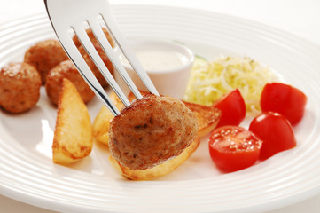 Fried meatballs with chips and vegetable salad