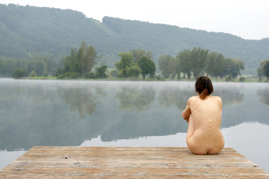 Fototapeta Young nude woman at the lake on a misty autumn morning