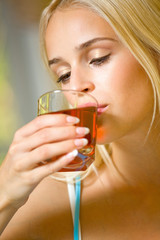 Portrait of young beautiful woman with glass of juice, indoors