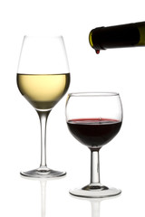 Red wine being poured into a glass and a glass of white wine