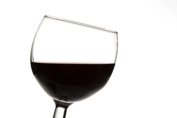 Slanted glass of red wine, isolated on a white background.