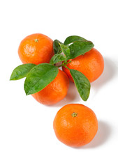 a group of four tangerines with leaves