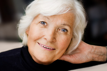 Charmante Seniorin mit Hand im Haar