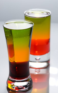 Two shot glasses with colorful cocktails