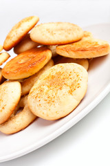 a big pile of ginger cookies on a white plate