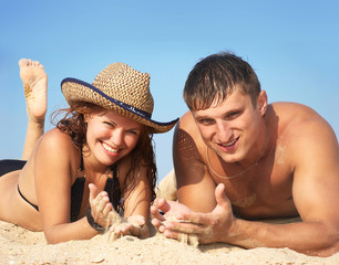 boy and girl lay on sand