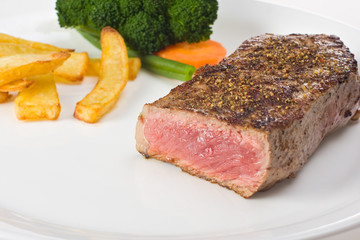 gegrilltes Steak auf einem Teller mit Pommes frites und Gemüse