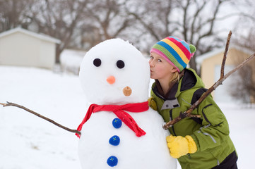 Cute Young Girl Kisses Snowman
