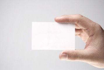 Mão segurando um cartão pessoal branco