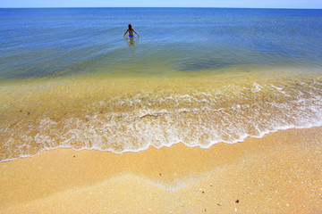 Beautiful sandy beach against blue sky and crystal blue water