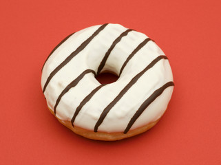 doughnut with chocolate glacing on red background