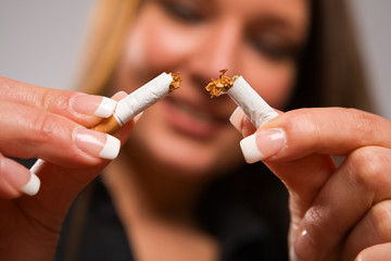 Woman breaking cigarette with manicured hands