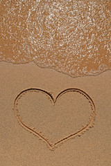 Heart drawing on sandy beach