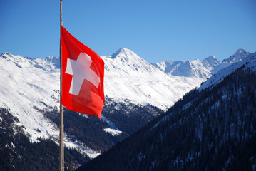 Schweizer Flagge vor schneebedeckten Bergen