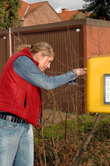 Frau am Briefkasten