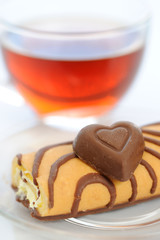 Cake and chocolate heart with cup of tea