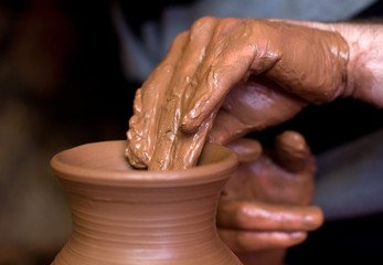Close up of hands of the potter creating utensils