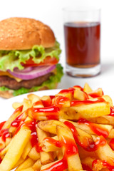 french fries with lots of ketchup with a cheeseburger an cola