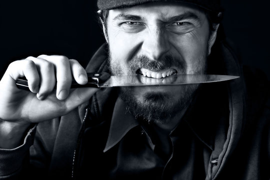 Funny tough guy biting knife with teeth