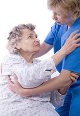 nurse helps the senior woman get up