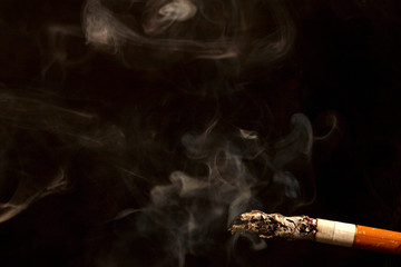 Smoking cigarette on black background