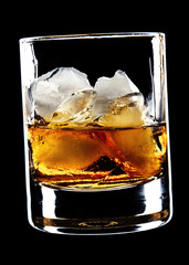 glass of whiskey and ice isolated over black background