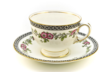 Floral patterned tea cup with saucer on a white background