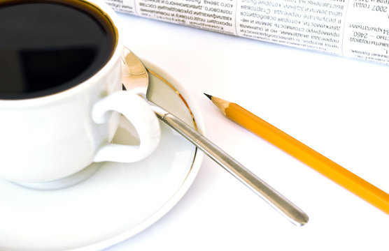 Cup of coffee and newspaper on white