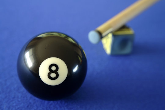 Pool ball, cue and chalk on blue table