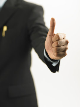 man in the business suit show hand sign of thumb up