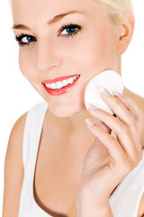 Woman using cotton pad on face