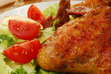 Grilled chicken wings with baked potatoes and vegetable salad