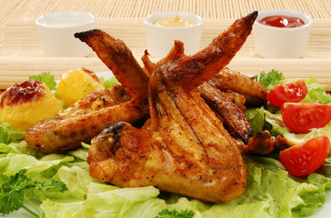 Grilled chicken wings with baked potatoes and vegetable salad