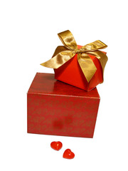 Two red gifts with a gold ribbon and two hearts