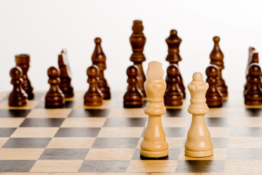 Chess on white - lonely white king and queen against blacks