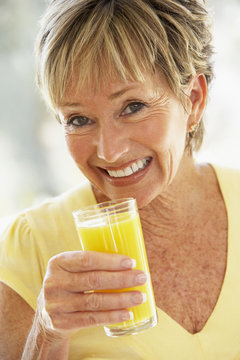 Woman Smiling At Camera Drinking Orange Juice
