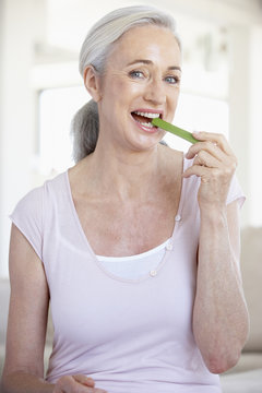 Senior Woman Eating A Celery Stick