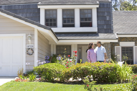 Couple Standing Outside Their House