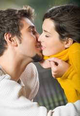Young attractive happy amorous couple kissing outdoors
