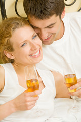 Young couple celebrating with champagne at bedroom